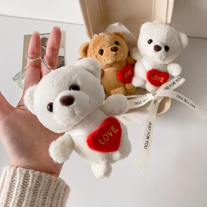 Detail of plush bear keychain with red heart embroidery and golden LOVE lettering