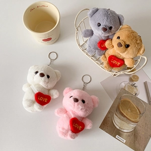Close-up of colorful plush bear keychains with red love embroidery in a white basket