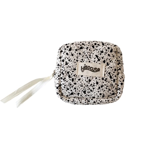 Quilted cotton cosmetics bag with black spotted ink pattern and white ribbon zipper pull