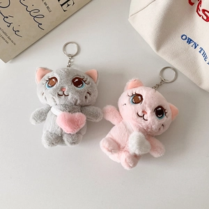 Detail of plush cat keychains in grey and pink with soft texture and heart pattern