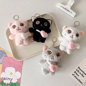 Cute plush cat keychains with heart crossbody bags in four colors on a decorative tray