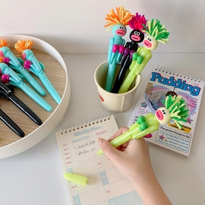 Macro shot of funny boxing pens with cartoon heads and colorful fiber hair in pastel tones