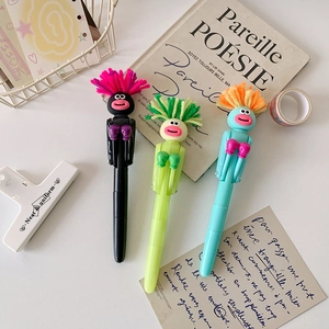Close-up of three funny boxing ballpoint pens with colorful plush hair on a desk