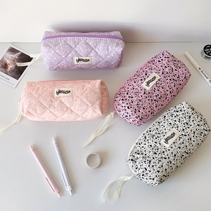 Quilted ink-splatter stationery bags with ribbon zippers in four assorted pastel patterns