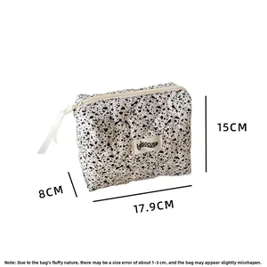 Vista dettagliata della borsa da trucco trapuntata con macchie di inchiostro e dimensioni