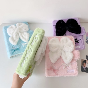 Macro shot of plush photo album cover with large ribbon and Bear Ribbon embroidery