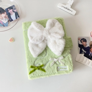 Detail of light green plush binder cover featuring white bows and magnetic closure