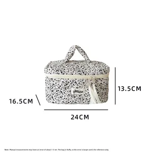 Detailed view of quilted makeup bag with ink splatter dots and size dimension info