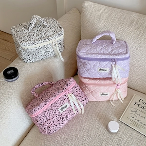 Detail view of large ink-splash pattern makeup bags with handles and ribbon zippers