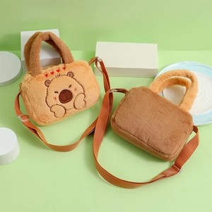 Detail of plush capybara crossbody bags with soft straps and embroidery in a soft scene