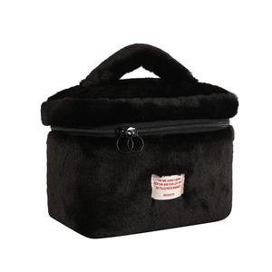 Detail of the black faux fur makeup bag featuring a soft texture and sturdy top handle