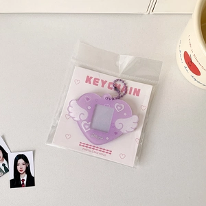 Close-up of purple heart-shaped photo holder with white angel wings and glitter finish