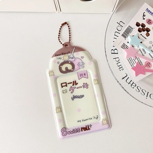 Détail du porte-carte crème avec motif de gâteau roulé et chaînette à billes en métal