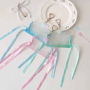 Close-up of clear gradient card holders with ribbon tassels and heart metal clips