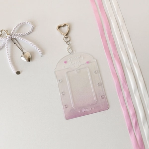 Detail van glitter pasjeshouder met hartsluiting en decoratieve roze linten erop