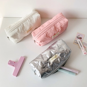 Three bow-patterned pencil cases in white pink and silver for stationery storage