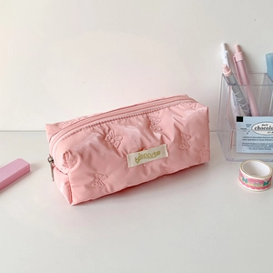 Close-up of pink puffy pencil case with quilted 3D bows and isocute fabric label