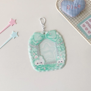 Macro view of light green cartoon rabbit card holder with star-shaped window and silver keychain