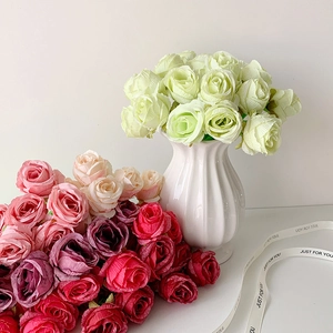 Detailed view of colorful artificial flower pens in a white ribbed ceramic vase with ribbon