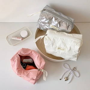 Quilted bow makeup bags in silver, white and pink with ribbon zippers for travel