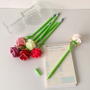 Macro detail of colorful rose floral stationery pens with green stem pens on a desk