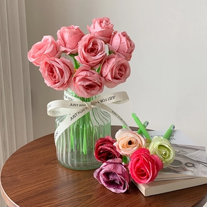 Detail of colorful artificial roses in a glass vase with a Just For You ribbon
