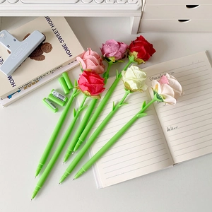 Creative 0.5mm rose flower ballpoint pens in colorful silk on a white desk setup