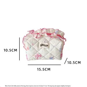 Detailed view of white quilted butterfly makeup bag with pink ruffles and size dimensions