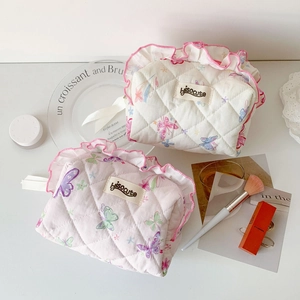 Close-up of quilted floral makeup bags with butterfly patterns and pink ruffle details