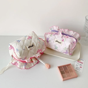 Detail of quilted butterfly makeup bag with delicate ruffled edges and soft cotton texture