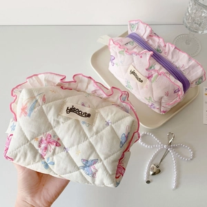 Detail of quilted lace makeup bags with butterfly prints and ruffled pink edges