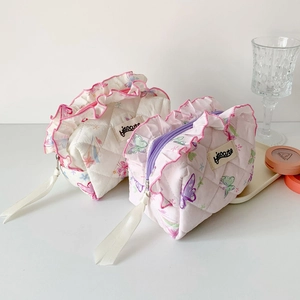 Detail of butterfly print quilted cosmetic bag with ruffles and silk ribbon zipper pull