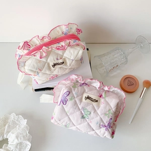 Detailed close-up of quilted butterfly makeup bag with delicate pink ruffle trim and zipper