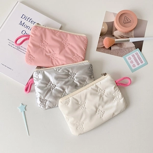 Quilted bow storage bags in pink, silver, and cream colors with metallic zipper detail