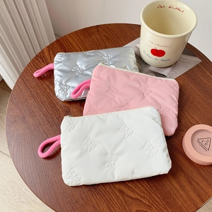 Detail of soft padded cosmetic pouches with 3D butterfly pattern and pink wrist straps