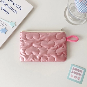 Detailed view of pink quilted storage bag with heart patterns and zipper puller
