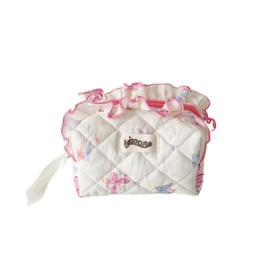 Quilted cotton makeup bag with pink butterfly patterns and decorative ruffle trim