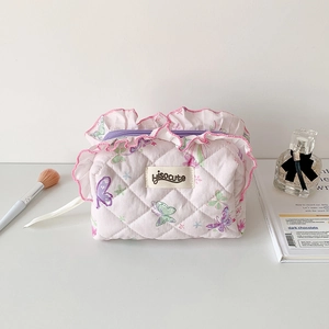 Detail of pink quilted makeup bag with butterfly print and ruffled edge finish