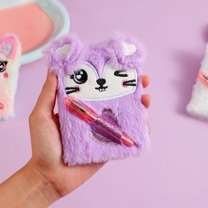 Close-up of purple plush notebook with fox embroidery and a pink glitter heart pen slot