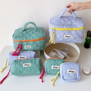 Detailed set of quilted checkered makeup bags with handles and vibrant contrast zippers