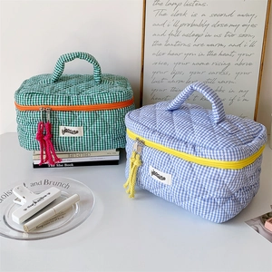 Detailed close-up of quilted checkered makeup bags with colorful zippers and handles