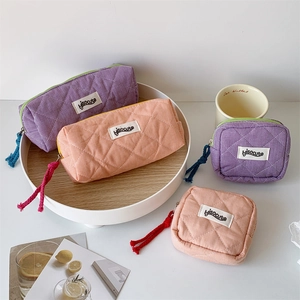 Detail of quilted checkered pouches with hisocute labels and cotton rope zipper pulls