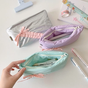Candy colored soft fabric pencil cases with pink ribbon bows in silver, violet and mint