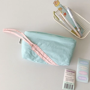Detail of light blue bow pencil case with pink handle on clean desk with stationery