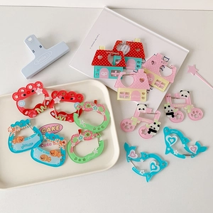 Macro view of cute acrylic carabiner charms with musical notes and house designs