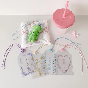 Gros plan de porte-cartes en PVC translucide avec cordons colorés et motifs floraux