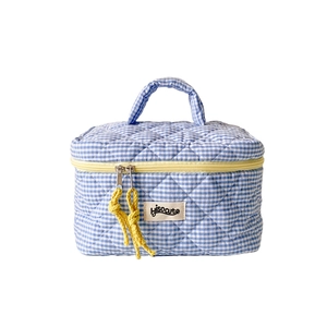 Blue and white checkered quilted makeup bag with bright yellow zipper and handle