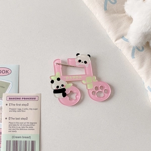 Close-up of pink acrylic music note charm with cute panda motifs and metal safety pin