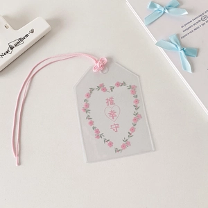 Détail de la pochette Omamori en PVC transparent avec motif de cœur et cordon rose