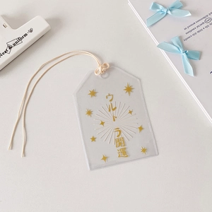 Détail du pendentif Omamori transparent avec texte doré et cordon en coton doux